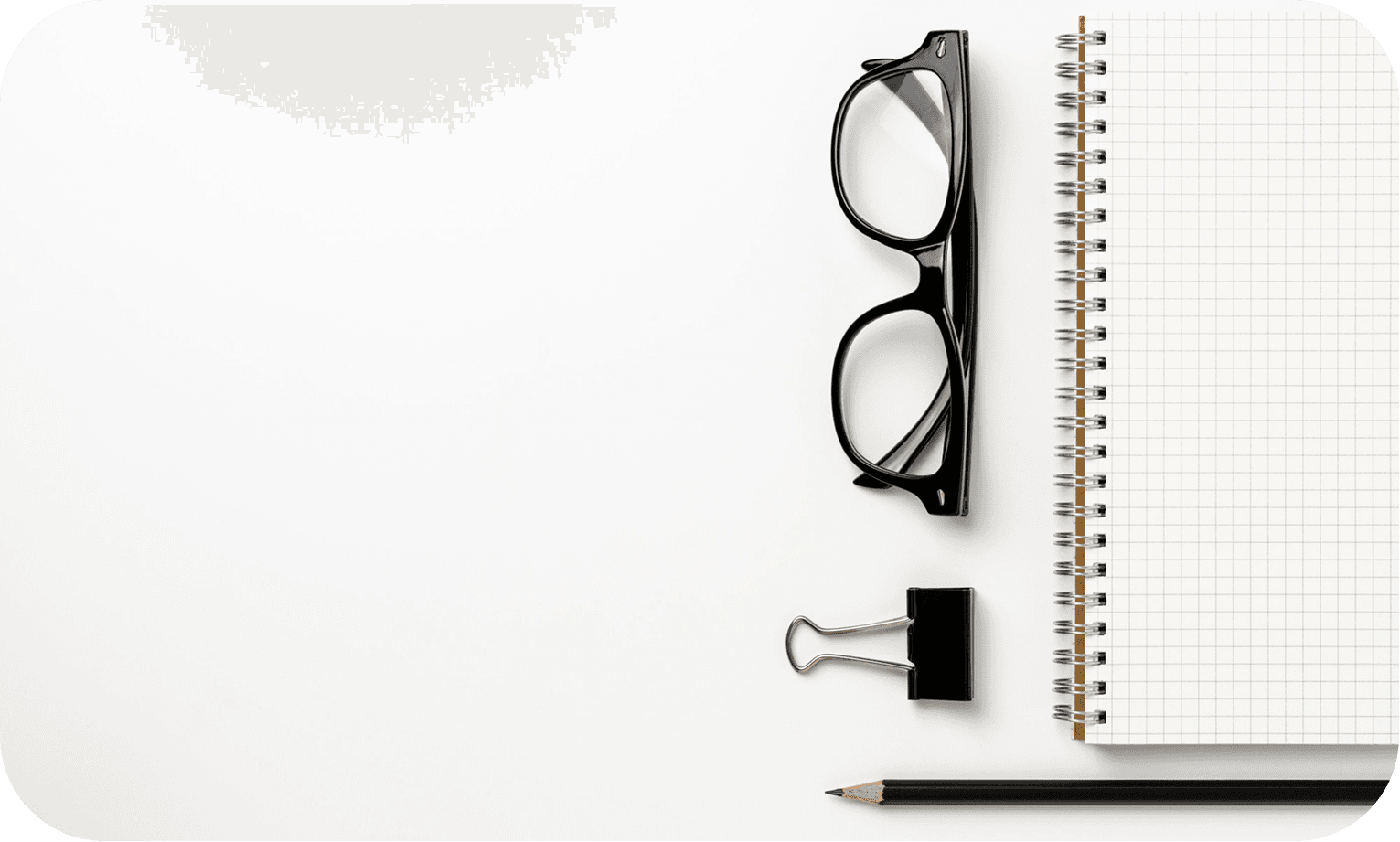 Glasses, notebook and pencil on a desk